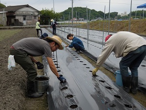 土をかけている写真